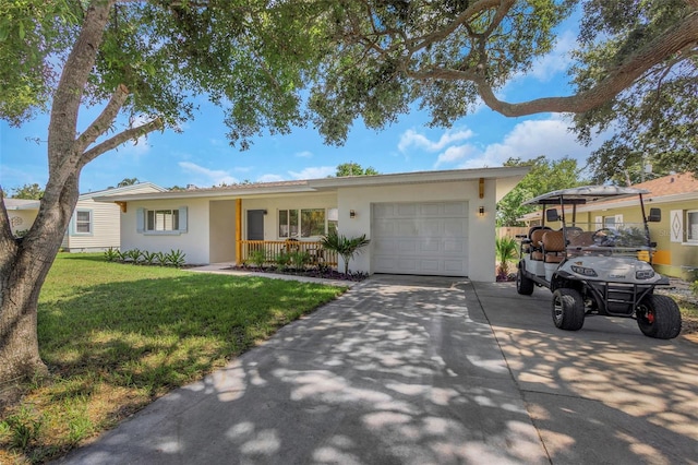 245 Grove Cir N, Dunedin, FL 34698 - ranch-style home with an attached garage, stucco siding, a front lawn, and driveway