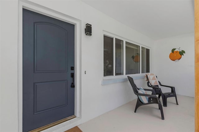 245 Grove Cir N, Dunedin, FL 34698 - doorway to property featuring stucco siding