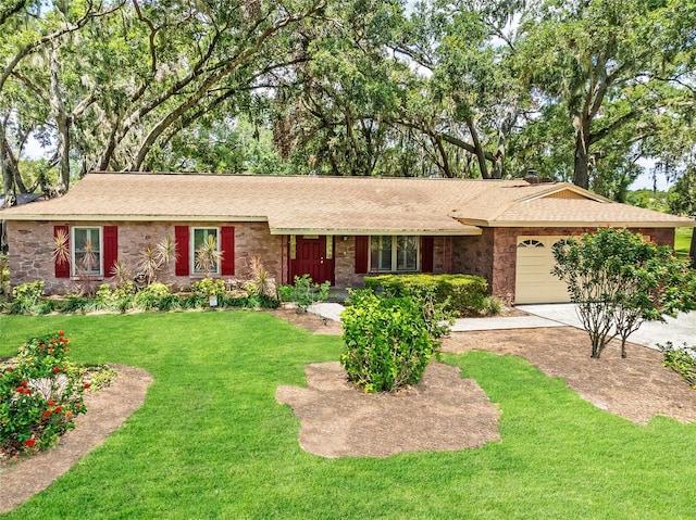 616 Pawn Way, Seffner, FL 33584 - ranch-style house featuring stone siding, an attached garage, a front yard, and driveway