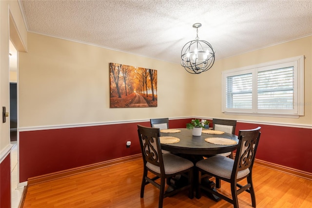 616 Pawn Way, Seffner, FL 33584 - dining room featuring wood finished floors, a chandelier, a textured ceiling, and crown molding
