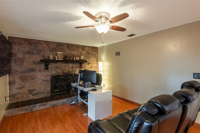 616 Pawn Way, Seffner, FL 33584 - living area featuring wood finished floors, a ceiling fan, ornamental molding, a textured ceiling, and a fireplace