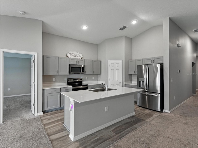 12931 Twin Bridges Dr, Riverview, FL 33579 - kitchen with appliances with stainless steel finishes, gray cabinetry, light countertops, carpet floors, and a kitchen island with sink