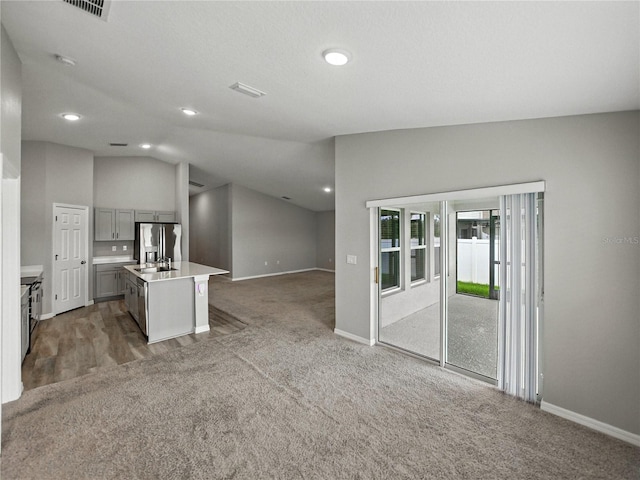 12931 Twin Bridges Dr, Riverview, FL 33579 - kitchen featuring stainless steel refrigerator with ice dispenser, gray cabinetry, open floor plan, lofted ceiling, and light countertops