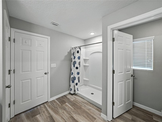 12931 Twin Bridges Dr, Riverview, FL 33579 - full bath featuring wood finished floors, a shower with curtain, and a textured ceiling
