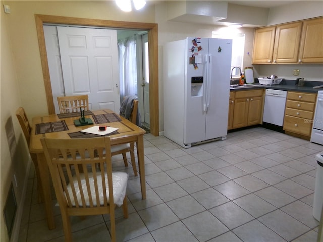 2239 Curtis Dr S, Clearwater, FL 33764 - kitchen with white appliances, dark countertops, light tile patterned floors, and light brown cabinetry