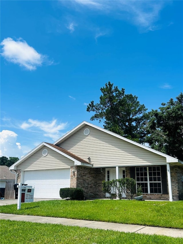 1990 Eclipse Dr, Middleburg, FL 32068 - ranch-style house featuring a garage, brick siding, a front yard, and driveway