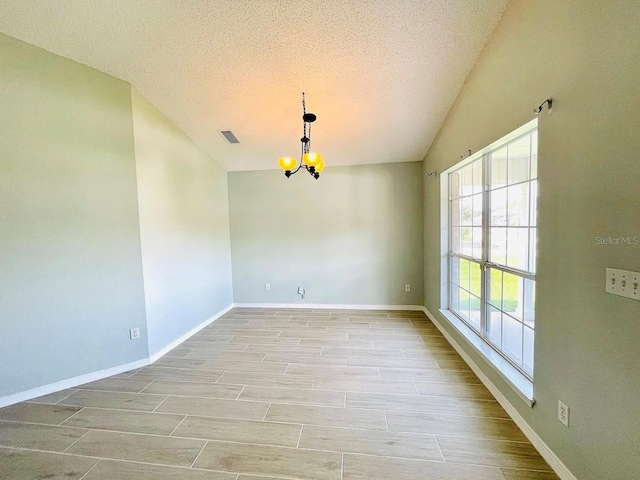 1990 Eclipse Dr, Middleburg, FL 32068 - spare room with a chandelier, a textured ceiling, light wood-type flooring, and vaulted ceiling