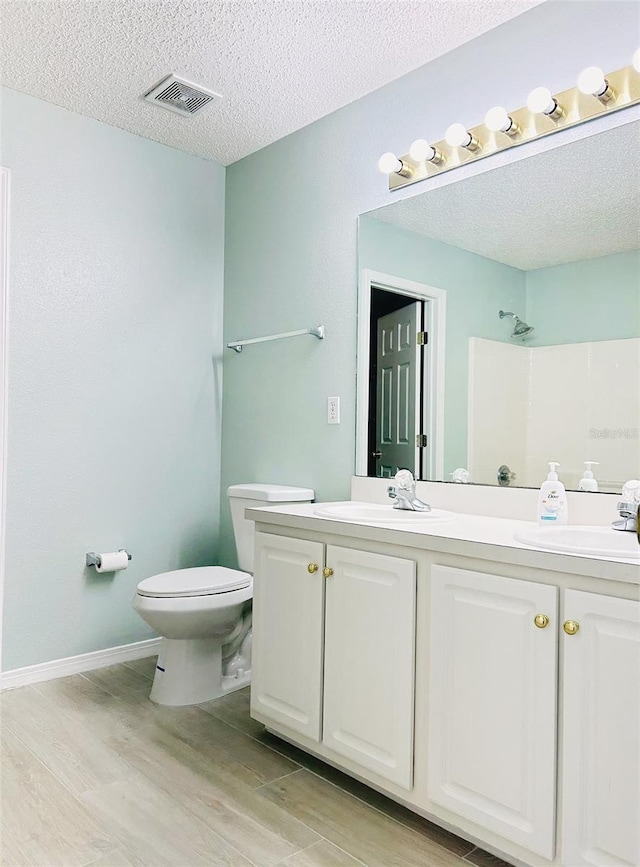 1990 Eclipse Dr, Middleburg, FL 32068 - bathroom with double vanity, wood finished floors, a textured ceiling, and a shower
