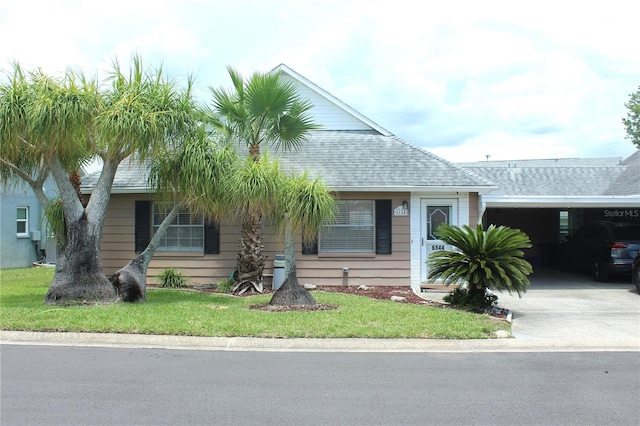 6144 Elmhurst Dr, New Port Richey, FL 34653 - view of front of property featuring an attached carport, driveway, a shingled roof, and a front yard