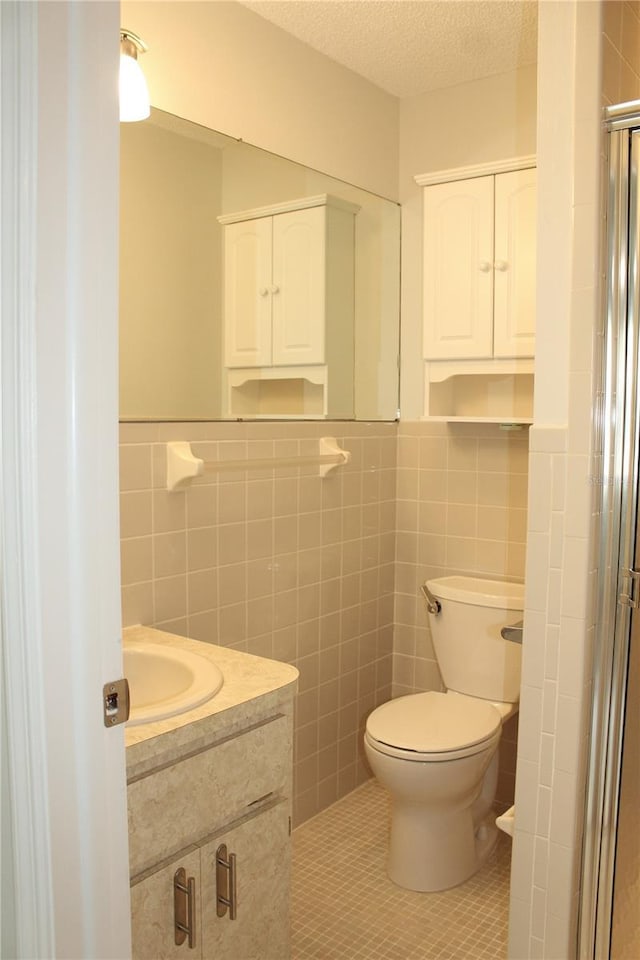 6144 Elmhurst Dr, New Port Richey, FL 34653 - bathroom featuring tile walls, vanity, a shower stall, tile patterned flooring, and a textured ceiling