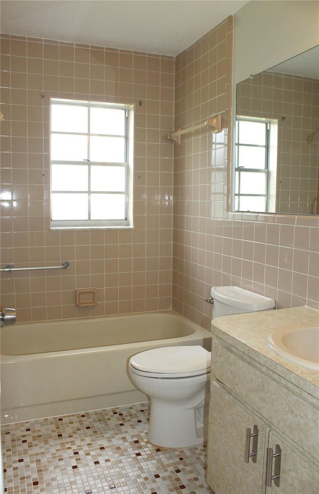 6144 Elmhurst Dr, New Port Richey, FL 34653 - bathroom featuring vanity, tile patterned floors, bathtub / shower combination, and tile walls