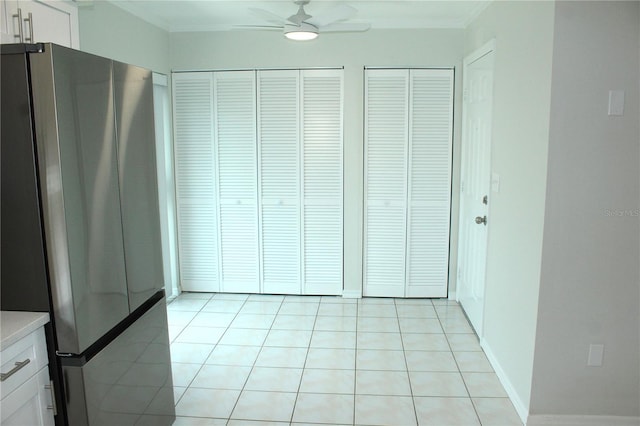 6144 Elmhurst Dr, New Port Richey, FL 34653 - unfurnished bedroom featuring freestanding refrigerator, multiple closets, light tile patterned floors, and crown molding