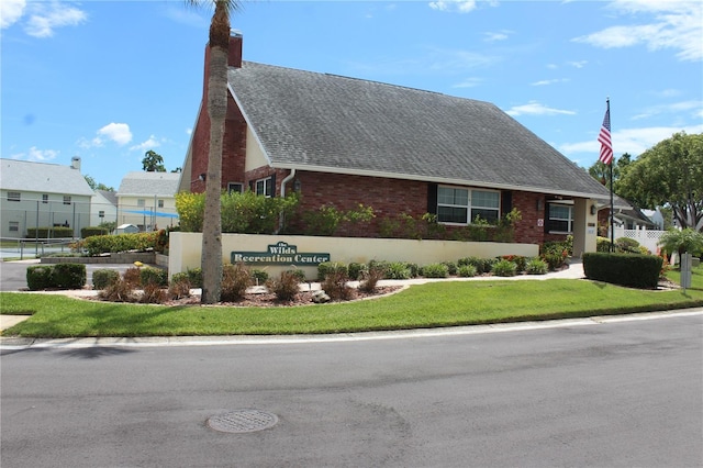6144 Elmhurst Dr, New Port Richey, FL 34653 - view of front of house with a shingled roof, a chimney, and brick siding