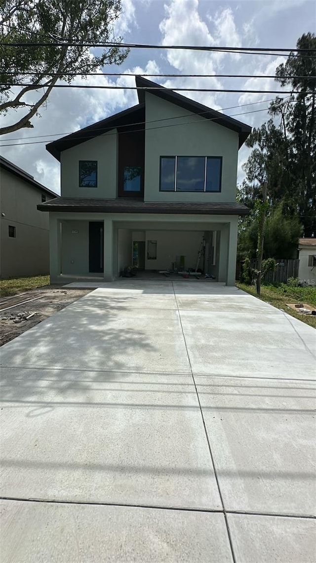 12240 Land St, Largo, FL 33773 - contemporary house featuring driveway, stucco siding, and a garage