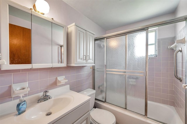 4911 Bartelt Rd, Holiday, FL 34690 - bathroom featuring vanity, shower / bath combination with glass door, tasteful backsplash, and tile walls