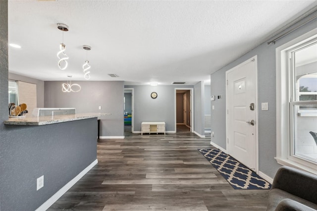 8897 54th St N, Pinellas Park, FL 33782 - entrance foyer featuring dark wood-style flooring, a textured ceiling, and a chandelier
