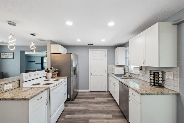 8897 54th St N, Pinellas Park, FL 33782 - kitchen with stainless steel appliances, white cabinetry, wood finished floors, backsplash, and recessed lighting