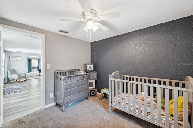 8897 54th St N, Pinellas Park, FL 33782 - bedroom featuring a textured wall, ceiling fan, and a nursery area