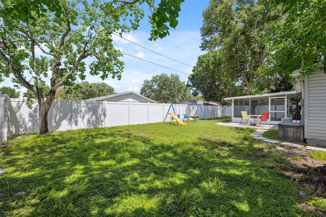 8897 54th St N, Pinellas Park, FL 33782 - fenced backyard featuring a playground, a sunroom, and a patio area