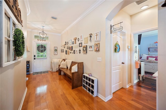 5102 Pheasant Woods Dr, Lutz, FL 33558 - entryway with light wood-style floors, ornamental molding, a chandelier, and arched walkways