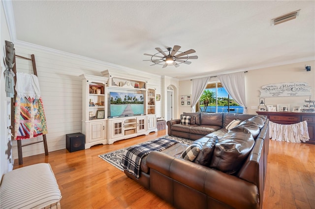 5102 Pheasant Woods Dr, Lutz, FL 33558 - living room with ornamental molding, light wood-style floors, ceiling fan, wood walls, and arched walkways