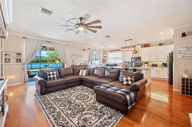 5102 Pheasant Woods Dr, Lutz, FL 33558 - living room with a ceiling fan, ornamental molding, light wood-style floors, recessed lighting, and a textured ceiling