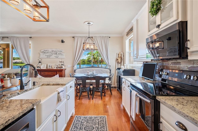 5102 Pheasant Woods Dr, Lutz, FL 33558 - kitchen featuring stainless steel electric range, a chandelier, light wood finished floors, dishwashing machine, and white cabinetry