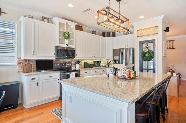 5102 Pheasant Woods Dr, Lutz, FL 33558 - kitchen with appliances with stainless steel finishes, crown molding, light wood-type flooring, white cabinetry, and recessed lighting
