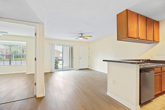 302 Lake Parsons Grn Unit 104, Brandon, FL 33511 - kitchen with dishwasher, a ceiling fan, a textured ceiling, brown cabinets, and light wood-style flooring