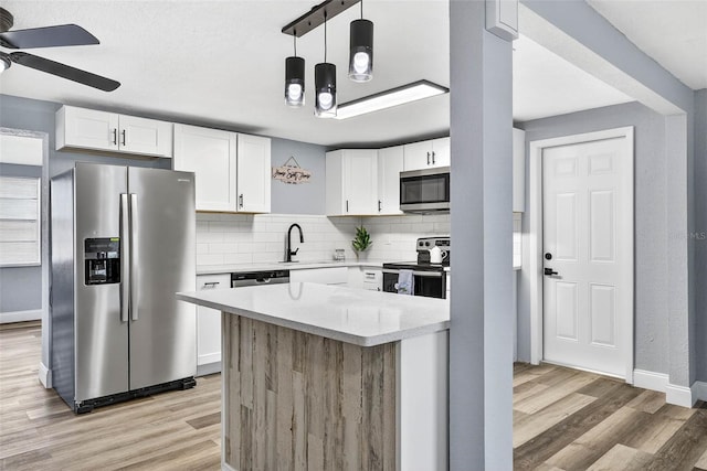 3330 Rock Royal Dr, Holiday, FL 34691 - kitchen featuring appliances with stainless steel finishes, light wood-style flooring, ceiling fan, and white cabinets