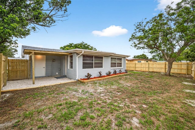 3330 Rock Royal Dr, Holiday, FL 34691 - rear view of property with stucco siding and a fenced backyard