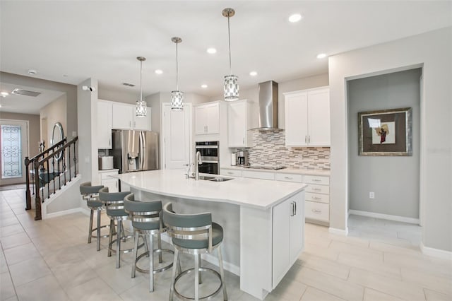 9107 Rally Spring Loop, Wesley Chapel, FL 33545 - kitchen with wall chimney exhaust hood, appliances with stainless steel finishes, an island with sink, tasteful backsplash, and a kitchen bar