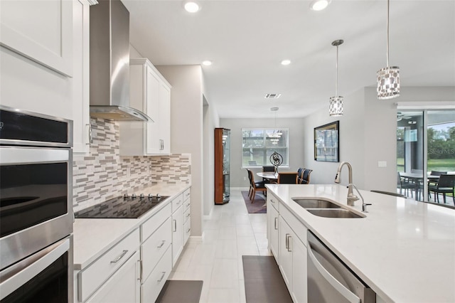 9107 Rally Spring Loop, Wesley Chapel, FL 33545 - kitchen with stainless steel appliances, wall chimney exhaust hood, decorative backsplash, light countertops, and hanging light fixtures