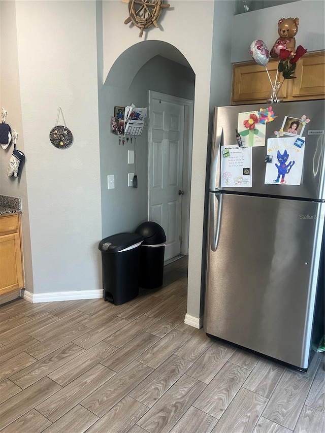 7719 Carriage Pointe Dr, Gibsonton, FL 33534 - kitchen featuring freestanding refrigerator, light wood-style floors, arched walkways, and brown cabinetry