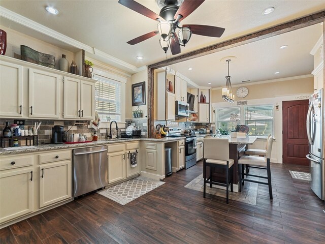 2504 W N A St Unit A, Tampa, FL 33609 - kitchen with appliances with stainless steel finishes, tasteful backsplash, crown molding, dark wood finished floors, and ceiling fan