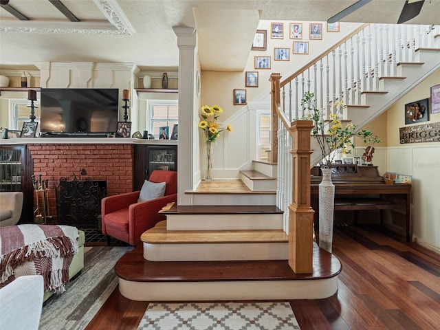 2504 W N A St Unit A, Tampa, FL 33609 - staircase featuring wood-type flooring, a fireplace, a wainscoted wall, and a decorative wall