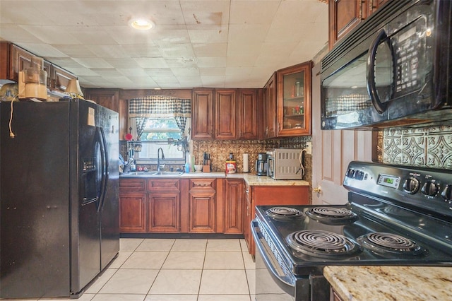 5651 6th St, Zephyrhills, FL 33542 - kitchen with black appliances, glass insert cabinets, light tile patterned flooring, backsplash, and light stone countertops