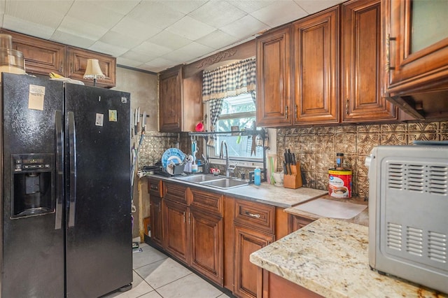 5651 6th St, Zephyrhills, FL 33542 - kitchen featuring black fridge, brown cabinetry, light tile patterned floors, and light countertops