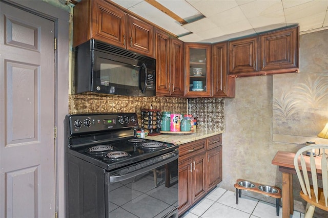 5651 6th St, Zephyrhills, FL 33542 - kitchen featuring black appliances, decorative backsplash, light tile patterned floors, glass insert cabinets, and brown cabinetry