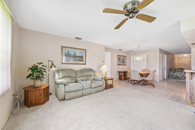 12156 Meadowbrook Ln, Largo, FL 33774 - living area with a ceiling fan, a textured ceiling, carpet, and a chandelier