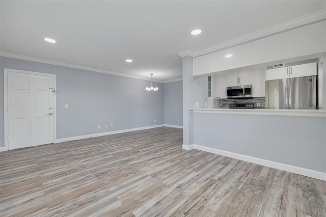 2525 W Bay Dr Unit A46, Largo, FL 33770 - unfurnished living room featuring a chandelier, crown molding, light wood-type flooring, and recessed lighting