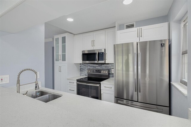 2525 W Bay Dr Unit A46, Largo, FL 33770 - kitchen with appliances with stainless steel finishes, glass insert cabinets, tasteful backsplash, recessed lighting, and light countertops