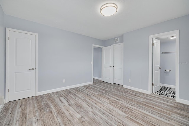 2525 W Bay Dr Unit A46, Largo, FL 33770 - unfurnished bedroom featuring wood finished floors and ensuite bath