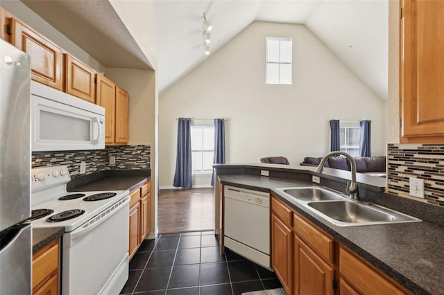 6017 Westgate Dr Unit 924, Orlando, FL 32835 - kitchen with white appliances, dark countertops, vaulted ceiling, backsplash, and dark tile patterned floors