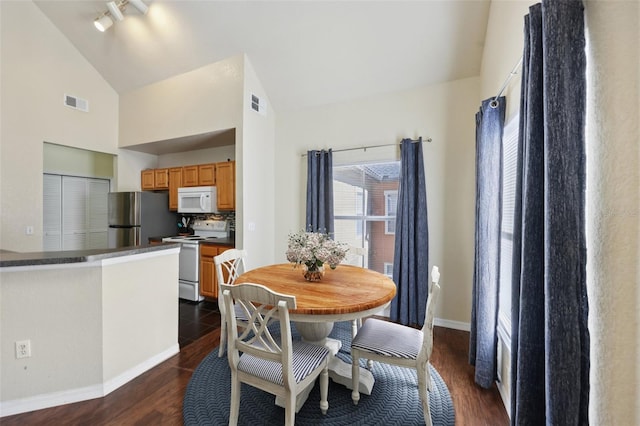 6017 Westgate Dr Unit 924, Orlando, FL 32835 - dining space with dark wood-style flooring, track lighting, and high vaulted ceiling