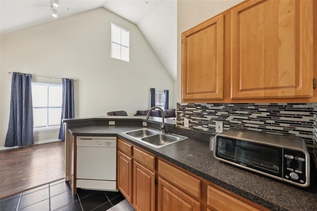 6017 Westgate Dr Unit 924, Orlando, FL 32835 - kitchen featuring dishwasher, vaulted ceiling, dark countertops, dark tile patterned floors, and decorative backsplash