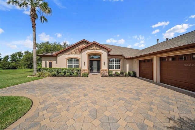 11729 Newberry Grove Loop, Riverview, FL 33579 - mediterranean / spanish home with decorative driveway, a garage, stucco siding, stone siding, and a front lawn