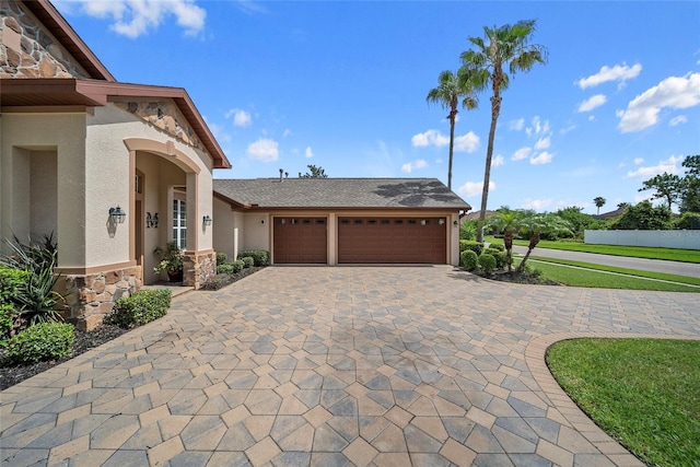 11729 Newberry Grove Loop, Riverview, FL 33579 - view of front of property with stone siding, stucco siding, an attached garage, and decorative driveway