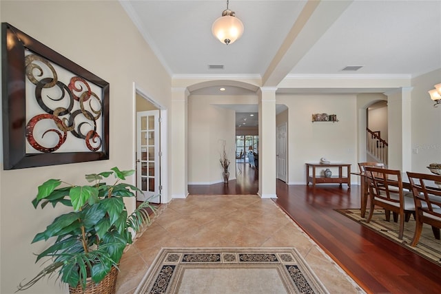 11729 Newberry Grove Loop, Riverview, FL 33579 - entrance foyer featuring arched walkways, decorative columns, crown molding, light tile patterned floors, and stairs
