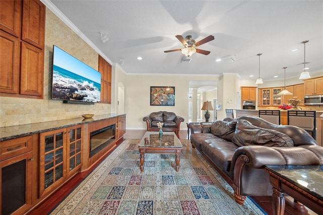 11729 Newberry Grove Loop, Riverview, FL 33579 - living area with arched walkways, a ceiling fan, recessed lighting, a glass covered fireplace, and dark wood-type flooring